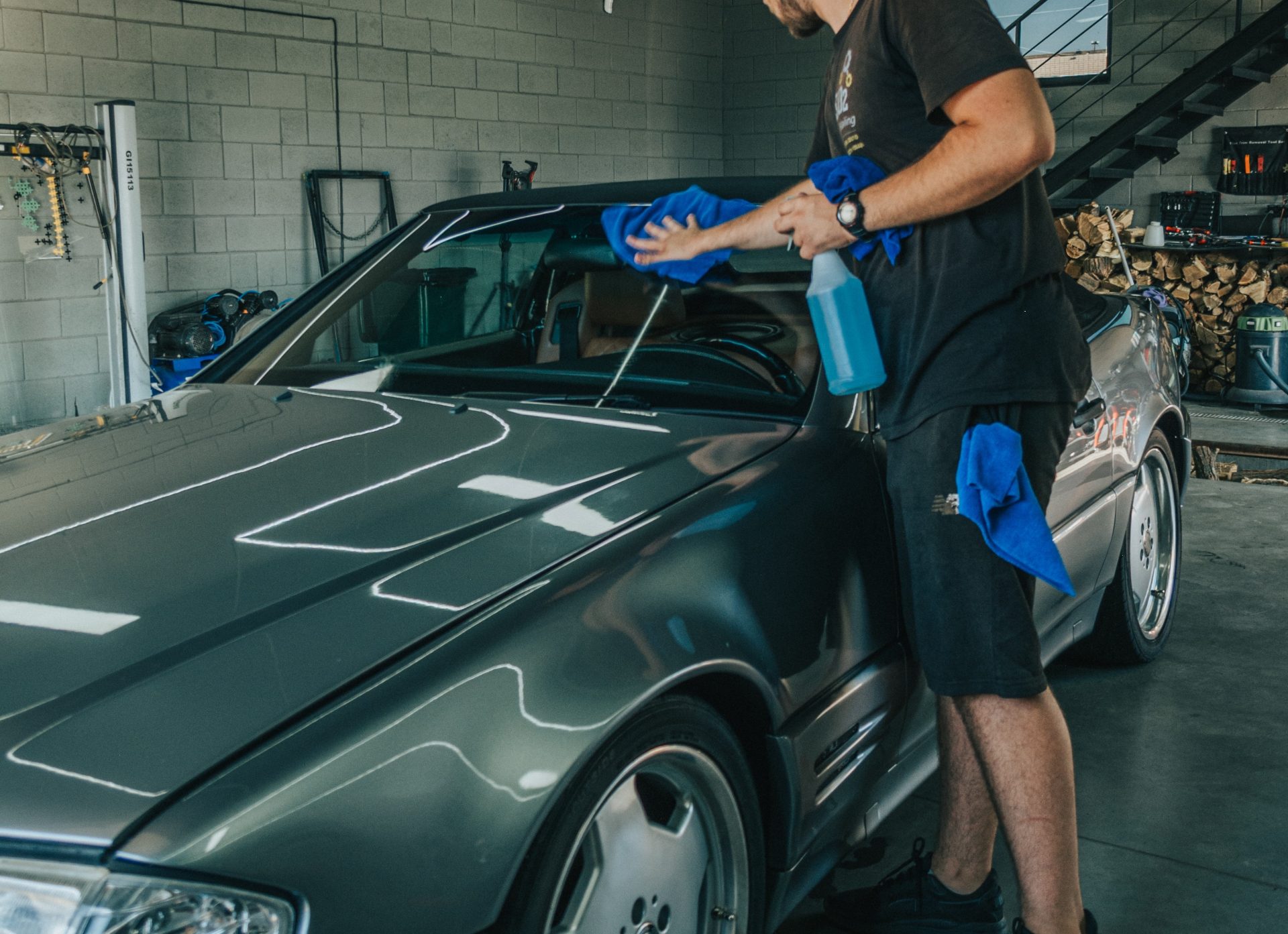 A skilled professional meticulously wipes and details a car, bringing out its natural shine through careful cleaning and detailing processes, resulting in a brilliantly polished and lustrous finish